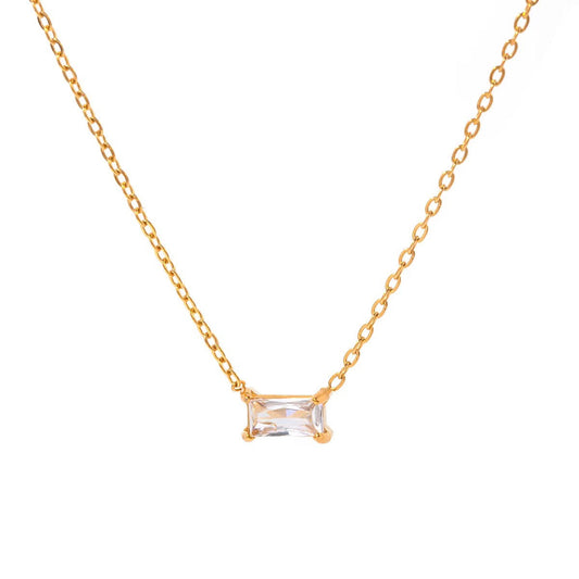 Gold necklace with a rectangular clear gemstone on a white background